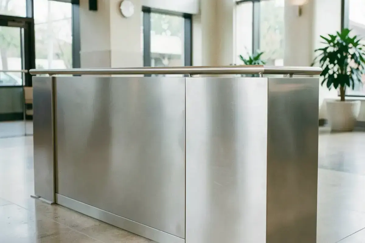 A large architectural stainless steel railing panel with a brushed satin finish in a modern lobby